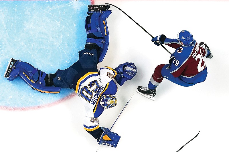 Blues goaltender Jordan Binnington blocks a shot by Avalanche center Nathan MacKinnon during the third period in Game 2 of a Stanley Cup second-round playoff series Thursday in Denver. (Associated Press)