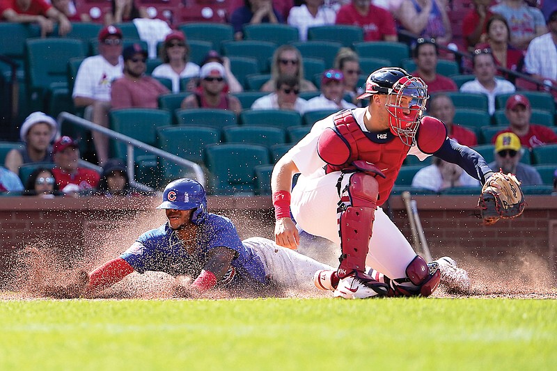 Nelson Velazquez of the Cubs scores past Cardinals catcher Andrew Knizner during the 10th inning of Sunday afternoon's game in St. Louis. (Associated Press)