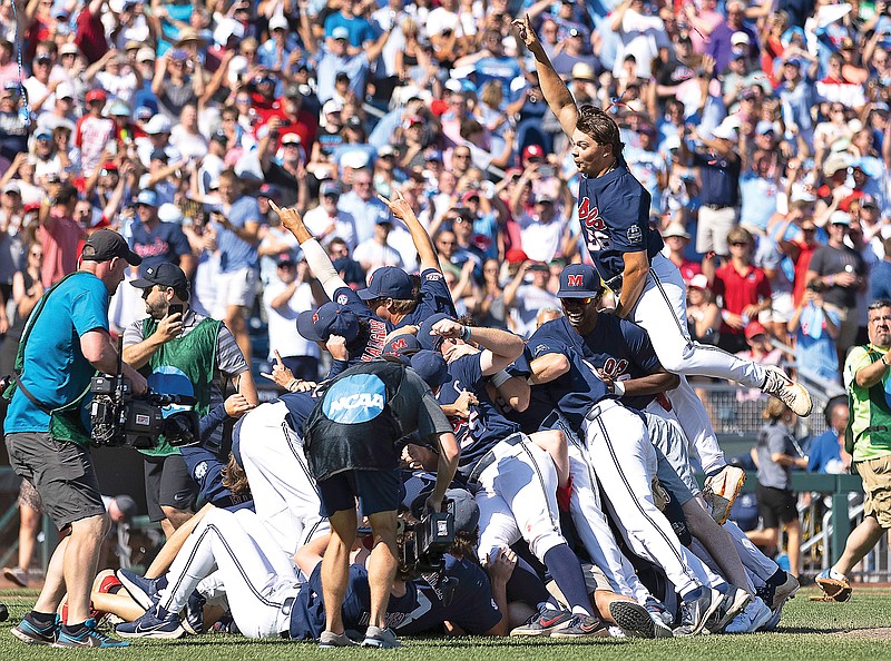 Mississippi's Jack Washburn (right) leaps on top of the team pile Sunday in celebration of the Rebels' 4-2 victory against Oklahoma in Game 2 of the College World Series baseball finals in Omaha, Neb. (Associated Press)