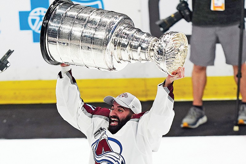 Avalanche center Nathan MacKinnon lifts the Stanley Cup after his team defeated the Lightning 2-1 in Sunday night's Game 6 of the Stanley Cup Final in Tampa, Fla. (Associated Press)