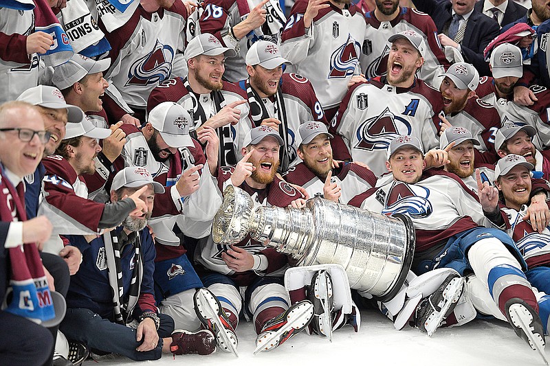 Avalanche players pose with the Stanley Cup after defeating the Lightning 2-1 in Sunday night’s Game 6 of the Stanley Cup Finals in Tampa, Fla. (Associated Press)