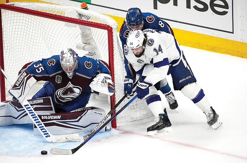Lightning left wing Pat Maroon (right) wraps around the net past Avalanche defenseman Cale Makar (back right) to put a shot on goaltender Darcy Kuemper during the second period of Game 5 of the Stanley Cup Final last Friday in Denver. (Associated Press)