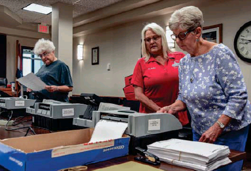 Jackie Beal, right, and Wilma Smith feed ballots through the machines to make sure each one tested accurately. Next to Beal is Michele Derlerth of the clerk's office.