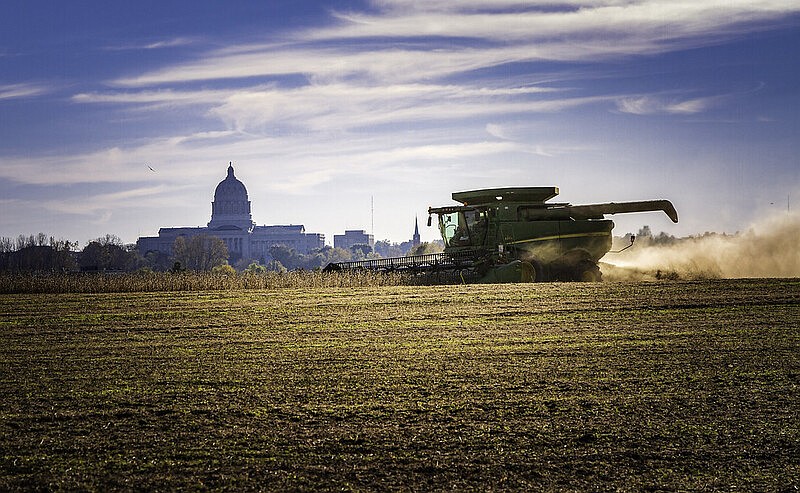 A grain farmer harvests near the State Capitol.