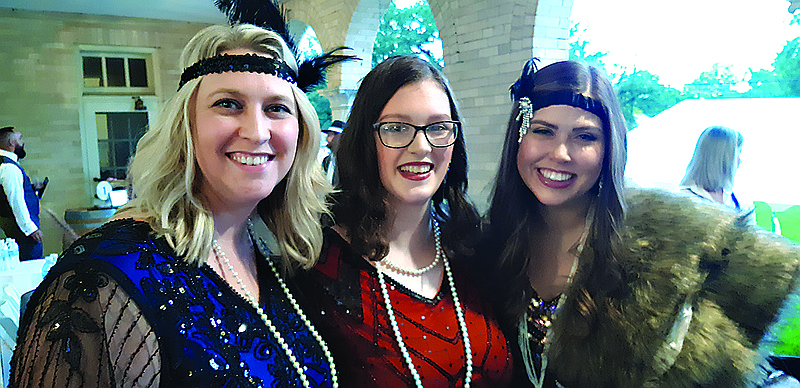 HandsOn Texarkana Executive Director Amy Lemley, from left, Ashtyn Striplin and Negen Revels show off their 1920s-style costumes at Tapas and Wine on Friday, Oct. 1, 2021, in Texarkana, Texas. This year's event is scheduled for Friday, Oct. 7, 2022. (Staff file photo by Junius Stone)