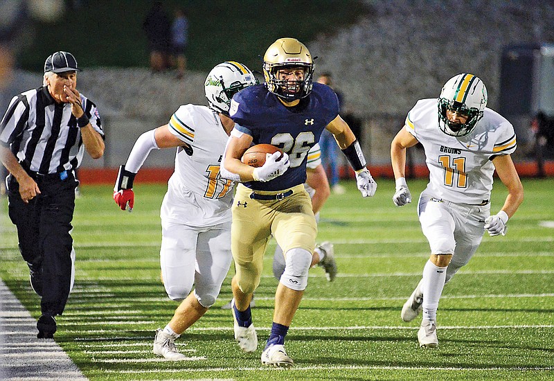 Helias running back Korbin Fisher runs past a pair of Rock Bridge defenders during Friday night’s game at Ray Hentges Stadium. (Eileen Wisniowicz/News Tribune)