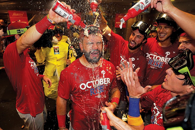 Kyle Schwarber celebrates with Phillies teammates after the team clinched a wild-card spot Monday night in Houston. (Associated Press)