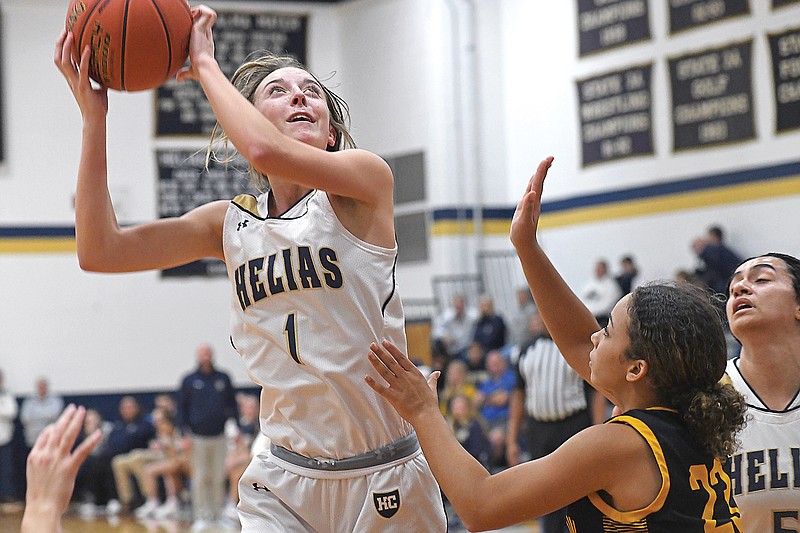 Ava Morris of Helias grabs a rebound and attempts to score a putback in front of Sedalia Smith-Cotton’s Kiara Murphy during Thursday night’s game at Rackers Fieldhouse. (Eileen Wisniowicz/News Tribune)