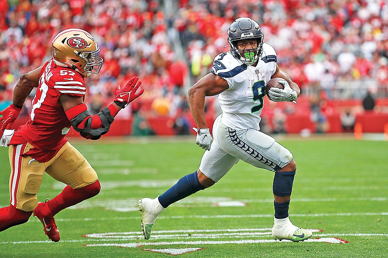 Seahawks running back Kenneth Walker III races for a touchdown against 49ers linebacker Dre Greenlaw during Saturday’s NFC wild-card playoff game in Santa Clara, Calif. (Associated Press)