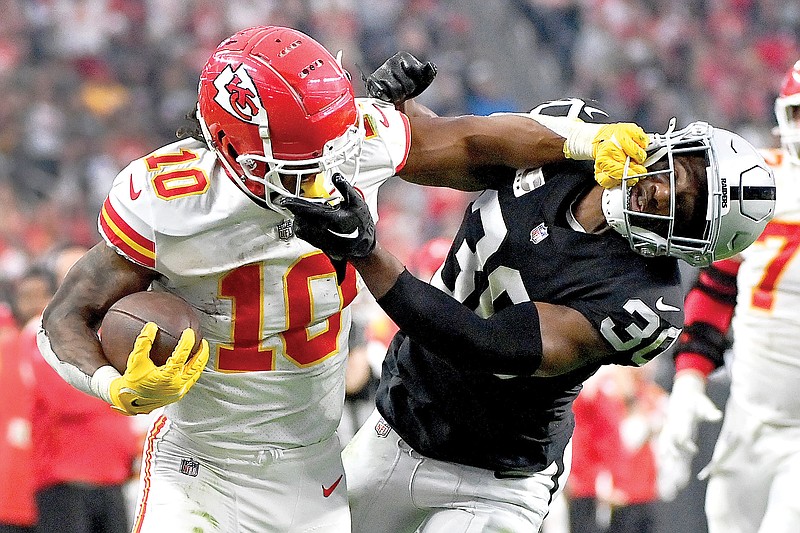 Chiefs running back Isiah Pacheco struggles for yardage as Raiders safety Duron Harmon tries to tackle him during the second half of a game earlier this month in Las Vegas. (Associated Press)