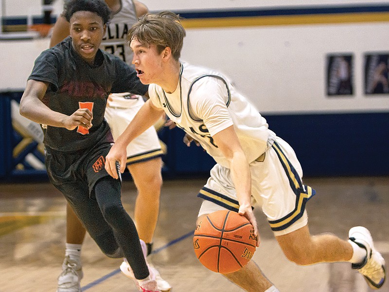 Sam Lopez of Helias dribbles the ball around Hogan Prep’s Jeremiah Flemons during Saturday night’s game in the Central Bank Shootout at Rackers Fieldhouse. (Josh Cobb/News Tribune)