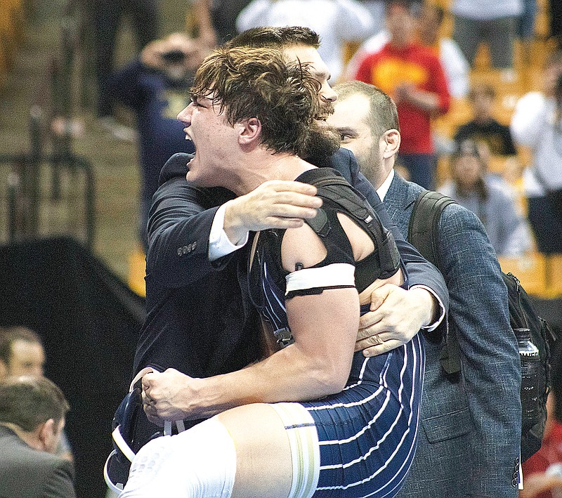 Logan Montoya is hugged by Helias coach Weston Keleher after defeating Bolivar’s Trey Brewer in the 175-pound title match Saturday night during the Class 3 boys wrestling state championships at Mizzou Arena in Columbia. (Kate Cassady/News Tribune)