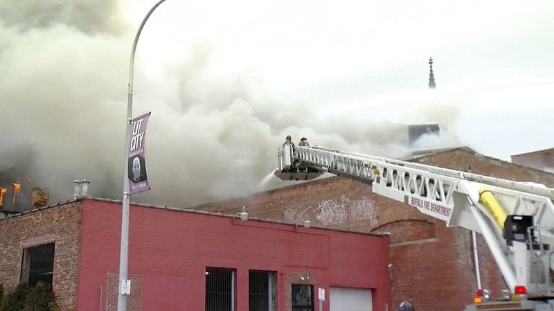 Firefighters battle a blaze in Buffalo, N.Y., on Wednesday, March 1, 2023. A firefighter battling a large fire in a vacant building in Buffalo on Wednesday became trapped in a partial building collapse and remained unaccounted for hours later, officials said. (WKBW via AP)