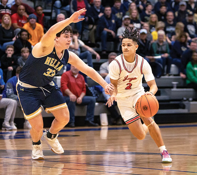 Jefferson City’s Kendric Johnson dribbles toward the lane against Trey Bexten of Helias during Friday night’s Class 5 District 5 Tournament semifinal game at Capital City High School. (Josh Cobb/News Tribune)