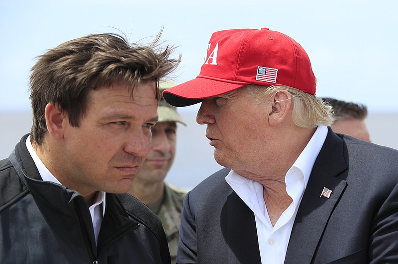 FILE - President Donald Trump talks to Florida Gov. Ron DeSantis, left, during a visit to Lake Okeechobee and Herbert Hoover Dike at Canal Point, Fla., March 29, 2019. Allies of former President Donald Trump have filed a complaint with the Florida Commission on Ethics accusing the state’s governor, Ron DeSantis, of violating campaign finance and ethics rules by running a shadow campaign for president. The complaint was filed Wednesday by MAGA, Inc. (AP Photo/Manuel Balce Ceneta, File)