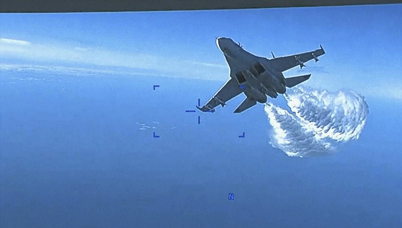 This photo taken from video released on Thursday, March 16, 2023, shows a Russian Su-27 approaching the back of the MQ-9 drone and beginning to release fuel as it passes, over the Black Sea, the Pentagon said. The Pentagon has released footage of what it says is a Russian aircraft conducting an unsafe intercept of a U.S. Air Force surveillance drone in international airspace over the Black Sea. (US Department of Defense via AP)