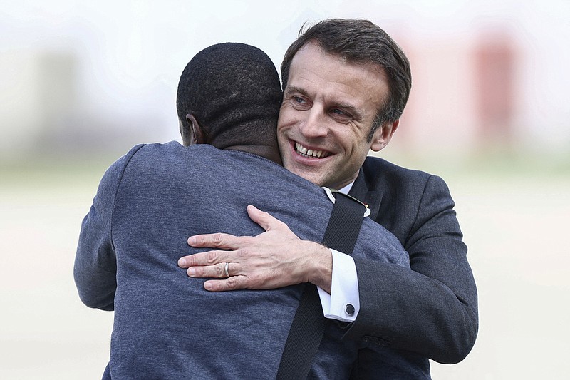 French President Emmanuel Macron, right, greets freed French hostage journalist Olivier Dubois, who was held hostage in Mali for nearly two years, upon his arrival at the military airport in Villacoublay, near Paris, Tuesday, March 21, 2023. (Yves Herman, Pool via AP)