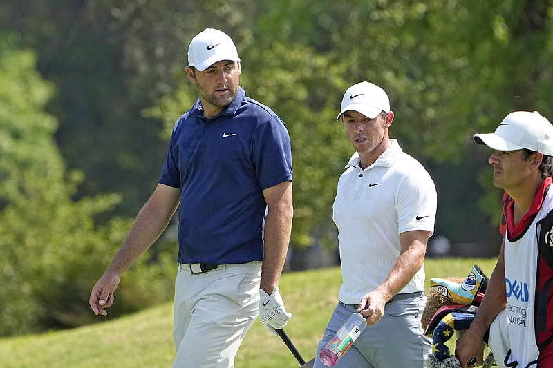 Scottie Scheffler and Rory McIlroy walk up the fairway on the fifth hole during Sunday's consolation match at the Match Play Championship in Austin, Texas. (Associated Press)