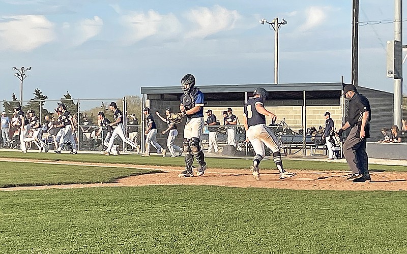 Sam Wyrick scores the winning run as his Helias teammates run on the field to celebrate after Friday night's game against St. Francis Borgia at the American Legion Post 5 Sports Complex. (Kyle McAreavy/News Tribune)