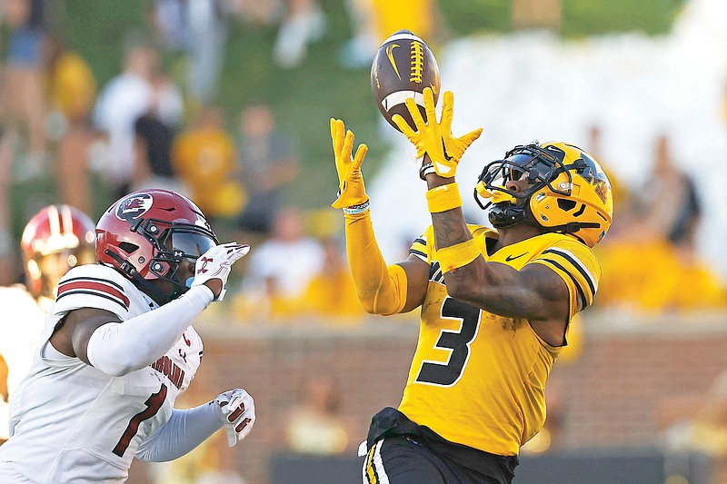 Missouri wide receiver Luther Burden catches a pass for a first down as South Carolina defensive back DQ Smith chases him during the second half of Saturday’s game at Faurot Field in Columbia. (Associated Press)