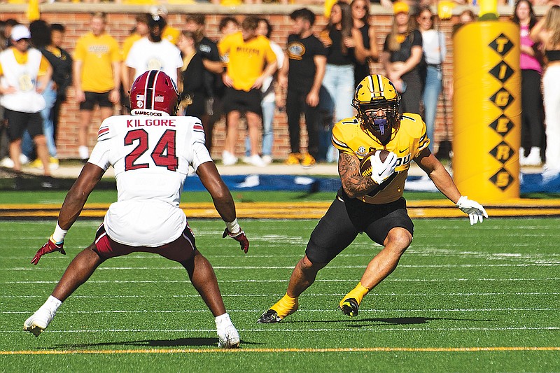 Missouri running back Cody Schrader carries the ball past South Carolina defensive back Jalon Kilgore during the first quarter of Saturday’s game at Faurot Field in Columbia. (Associated Press)
