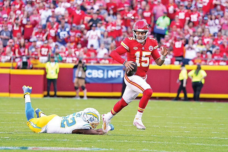 Chiefs quarterback Patrick Mahomes scrambles away from Chargers linebacker Khalil Mack during the second half of Sunday’s game at Arrowhead Stadium in Kansas City. (Associated Press)