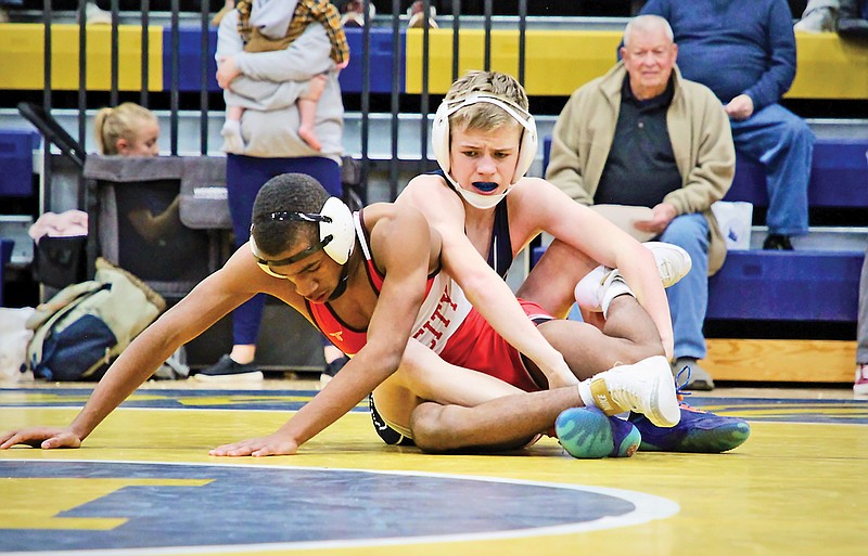 Alex Wieberg of Helias grabs hold of the legs of Jefferson City’s Tytus Oliver during their 120-pound match in Wednesday night’s Central Missouri Activities Conference dual at Rackers Fieldhouse. (Alexa Pfeiffer/News Tribune)