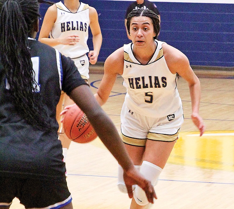 Claire Galbraith of Helias dribbles the basketball while being defended by Capital City’s Amaura Austell during Wednesday night’s game at Rackers Fieldhouse. (Alexa Pfeiffer/News Tribune)