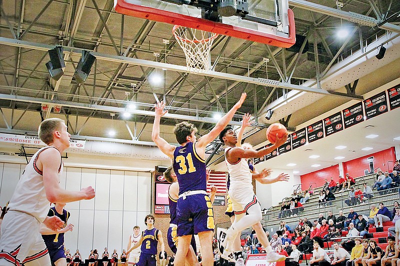 Jefferson City’s Judah Harris (right) goes to the basket for a layup around Camdenton’s Sterling Sederwall during last week’s first-round game in the Class 5 District 5 Tournament at Fleming Fieldhouse. (Alexa Pfeiffer/News Tribune)
