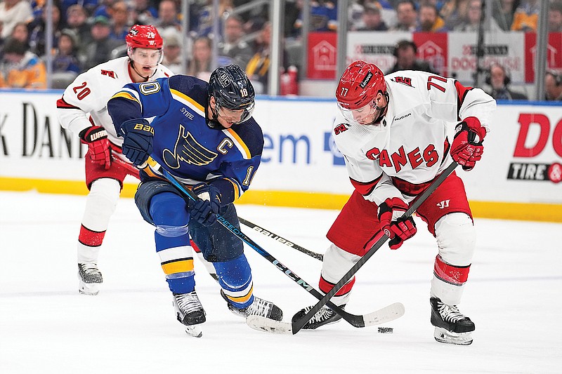 Brayden Schenn of the Blues and Tony DeAngelo of the Hurricanes battle for a loose puck during the second period of Friday night’s game at Enterprise Center in St. Louis. (Associated Press)
