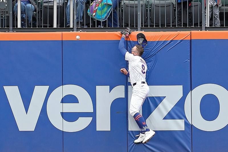 Mets outfielder Brandon Nimmo hit the wall trying to catch a home run hit by Salvador Perez of the Royals during the fourth inning of Saturday afternoon’s game in New York. (Associated Press)