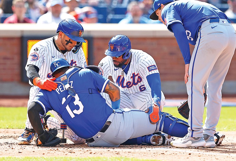 New York teammates Francisco Alvarez (left) and Starling Marte help Royals catcher Salvador Perez, who was injured on a play at the plate during the fourth inning of Sunday afternoon’s game in New York. (Associated Press)