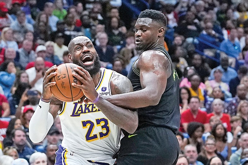 Lakers forward LeBron James drives to the basket against Pelicans forward Zion Williamson in the first half of Sunday’s game in New Orleans. James, the oldest player in the NBA this season, averaged 25.7 points per game. (Associated Press)