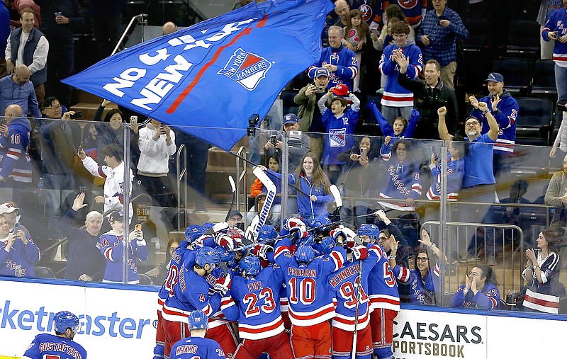 Rangers players and fans celebrate Saturday's shootout victory against the Islanders in New York. As the NHL playoffs begins this weekend, ushering in the most exciting hockey of the year, business is booming and the league has bounced back in a big way from the pandemic. (Associated Press)