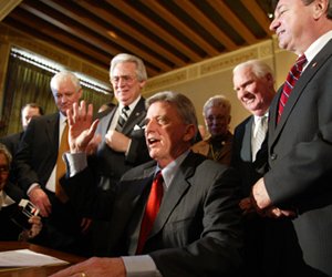 Gov. Mike Beebe waves to thank everyone who worked on the bill he just signed into law calling for a 50 percent sales tax cut on groceries at the state Capitol Thursday. Behind Beebe are (standng, from left) Senate President Pro Tem Sen. Jack Critcher, D-Batesville, Sen. Bobby Glover, D-Carlisle, former state Sen. Bud Canada, and Rep. David Evans, D-Searcy.