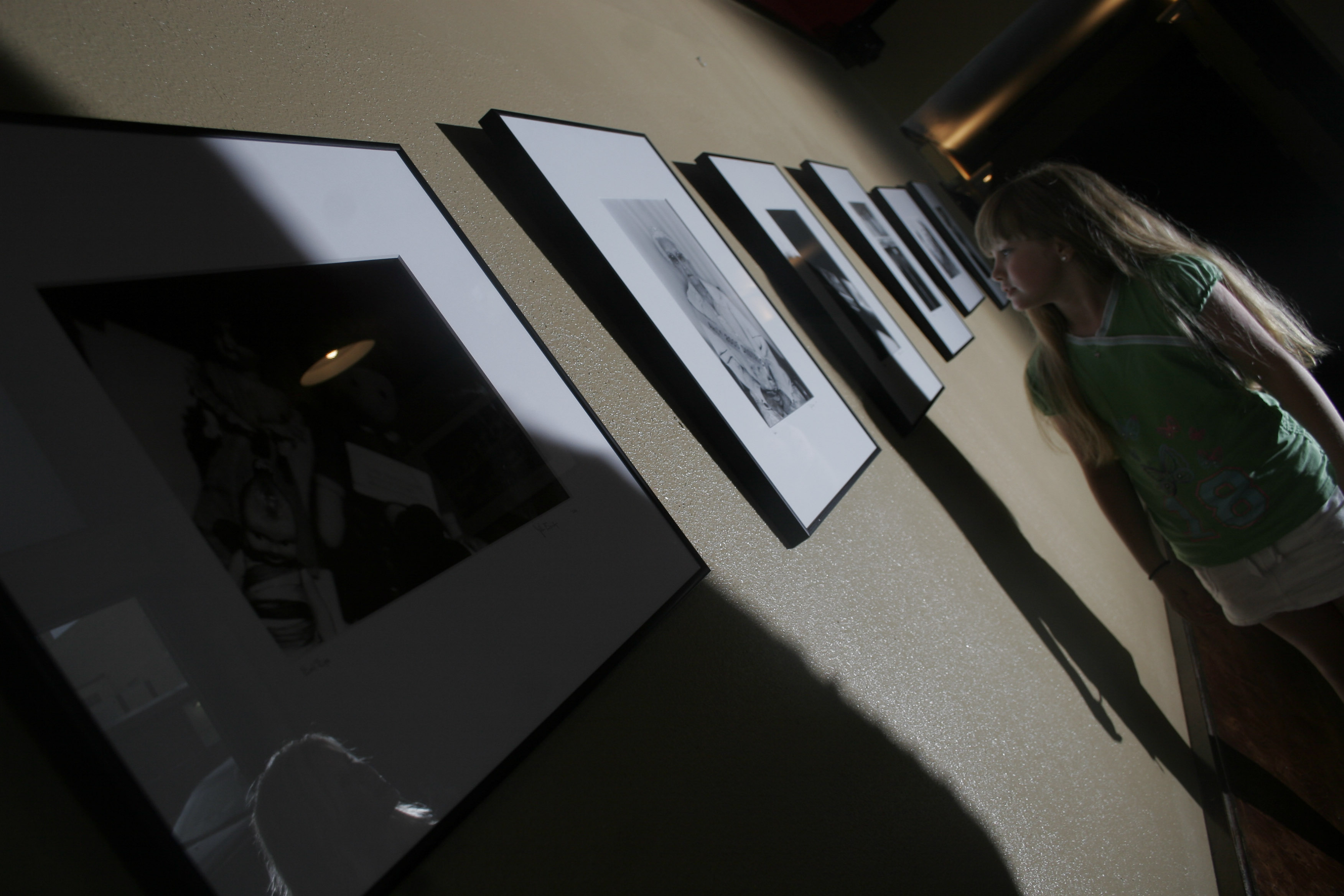 Griffyn Gentry, 7, stops to view photographs by John Bridges during a Thursday showing at EJ's in downtown Little Rock that also featured paintings by Stephano.