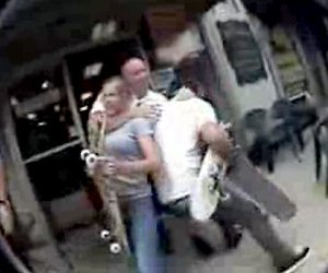 In this image taken from amatuer video, a police officer and skateboarders are seen scuffling on a sidewalk in Hot Springs.