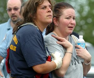 South Bend Fire District 10 firefighter Brenda Caler, left, consoles passenger Amy Corban of Smyrna, Ga. at the scene of a Greyhound bus wreck Monday. Another passenger who grabbed the steering wheel of the bus, causing it to wreck, is in the state mental hospital undergoing evaluation.