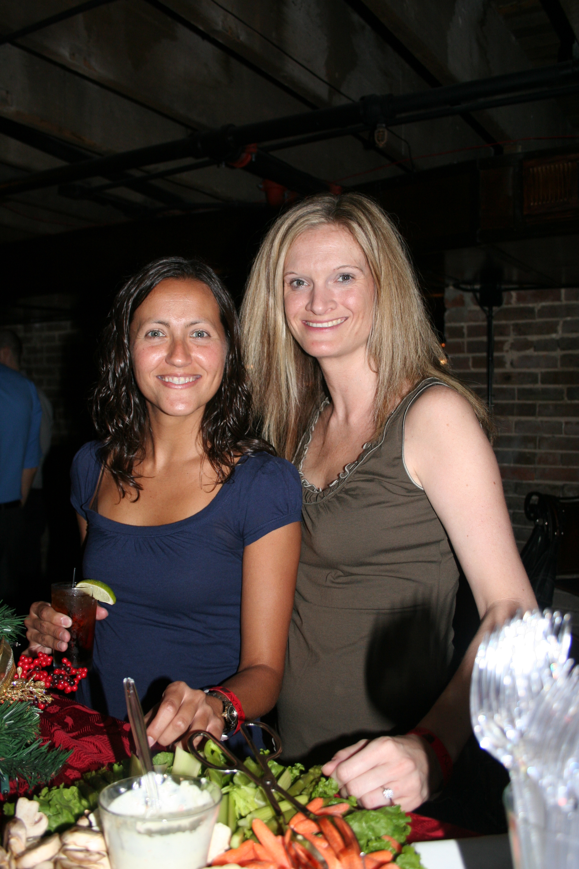 Bridget Bowman and Julianne Martindale graze the appetizer buffet at the AYPN Christmas in July party.
