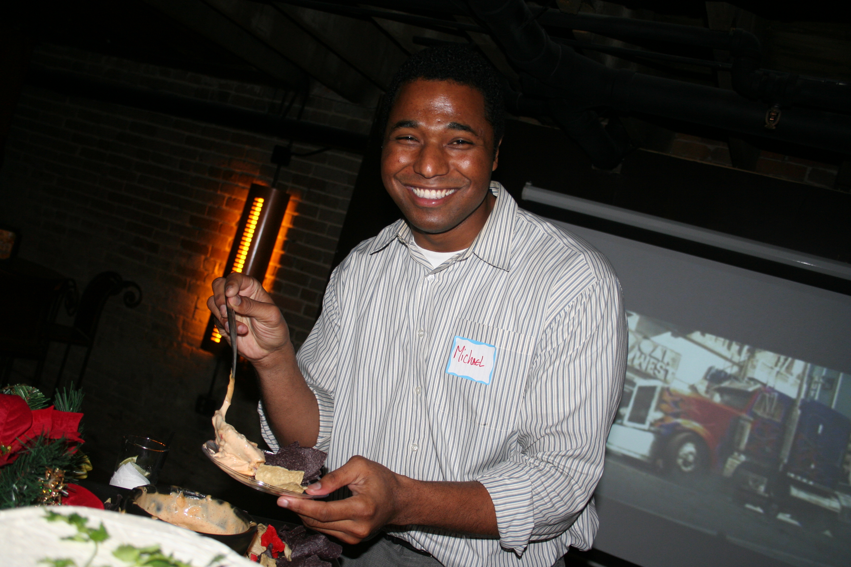 The camera surprises Michael Vickers as he grabs some finger foods from the buffet.