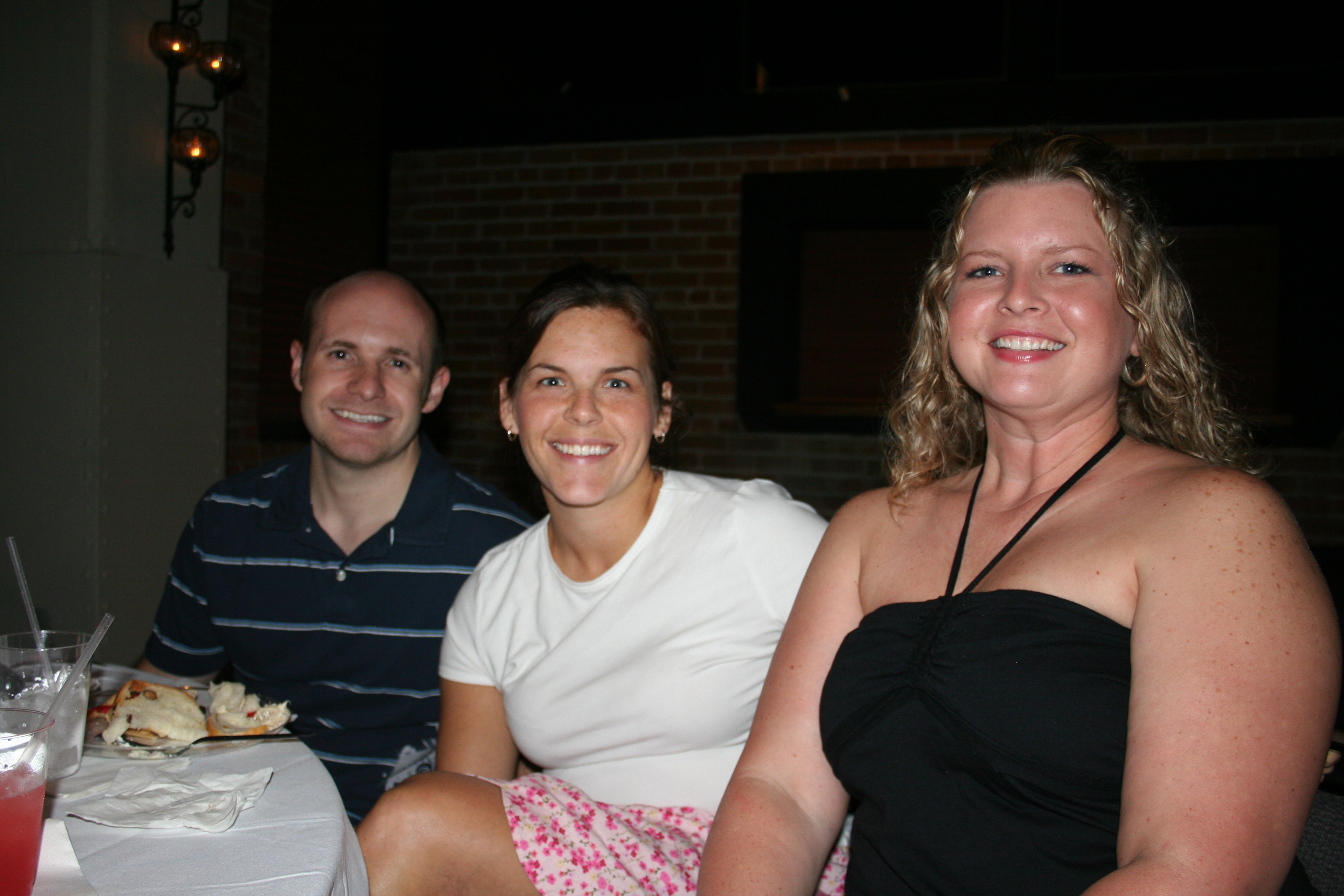 Dustin Hartung, Chris Hardesty and Christy Hartung eat and visit at the party.