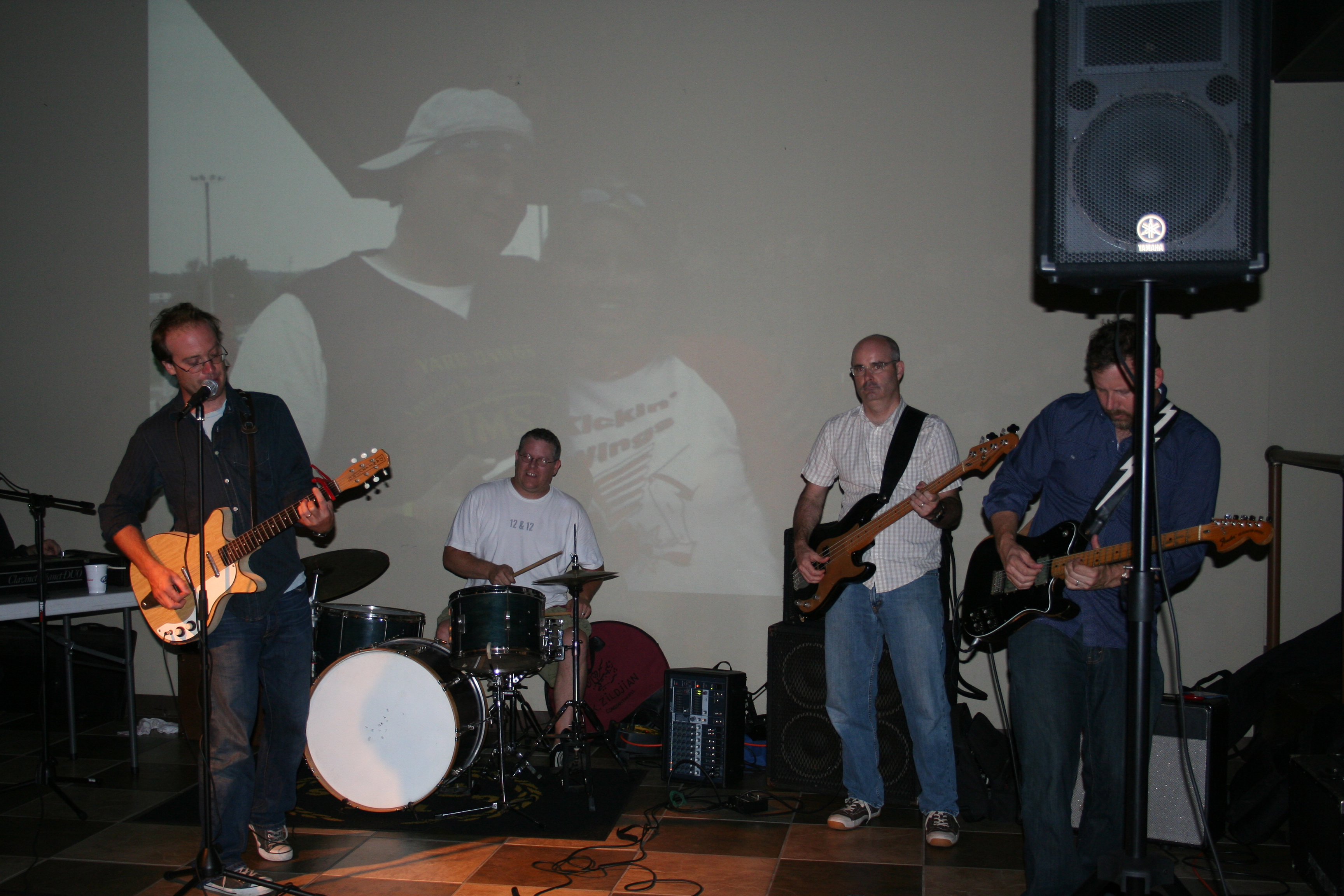 The Boondogs play in front of a slideshow of Little Rock Kickball members.