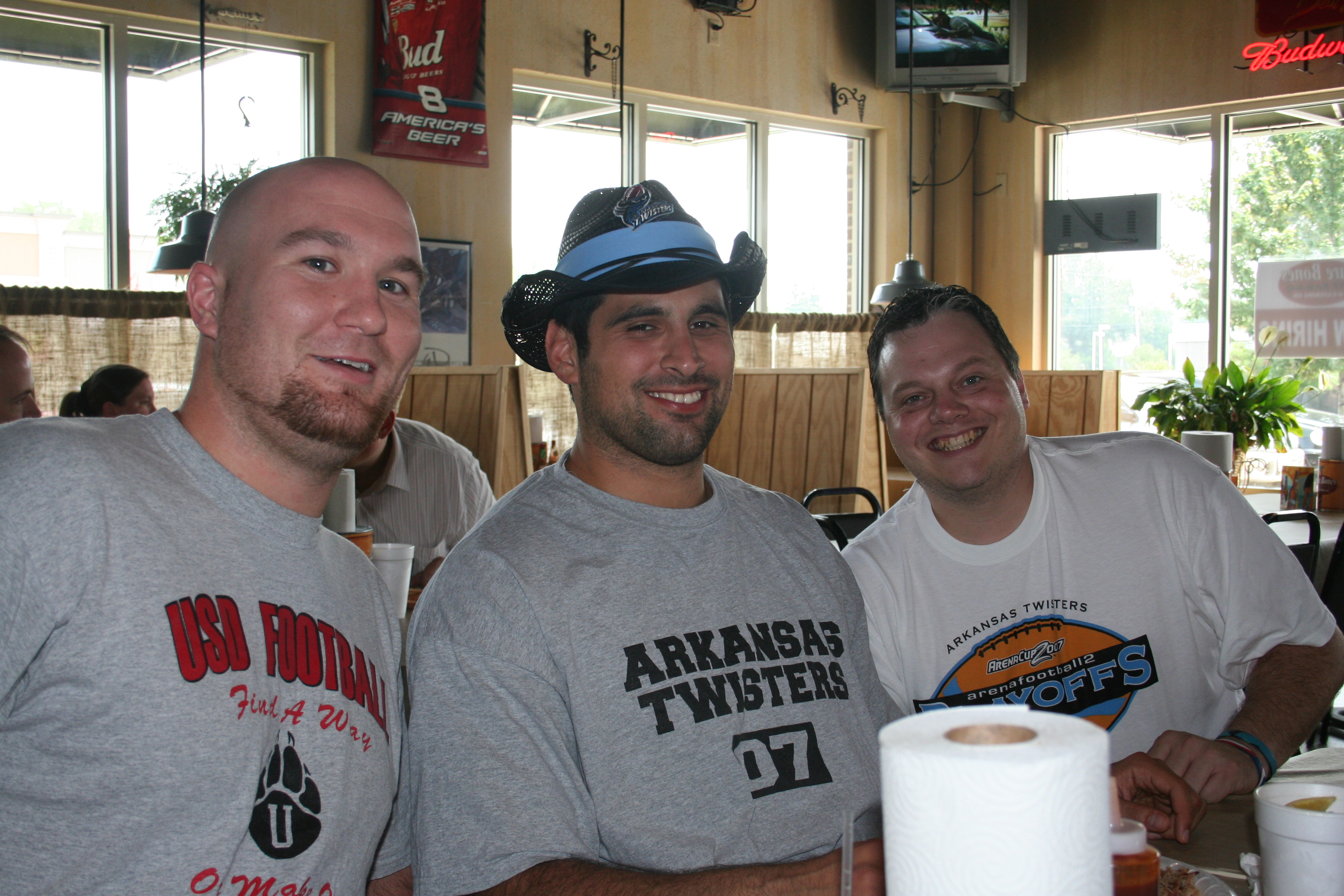Mike Matthes (D-Line) and Brian Villanueva (QB) sit with Jake Hatley at the Media Luncheon.