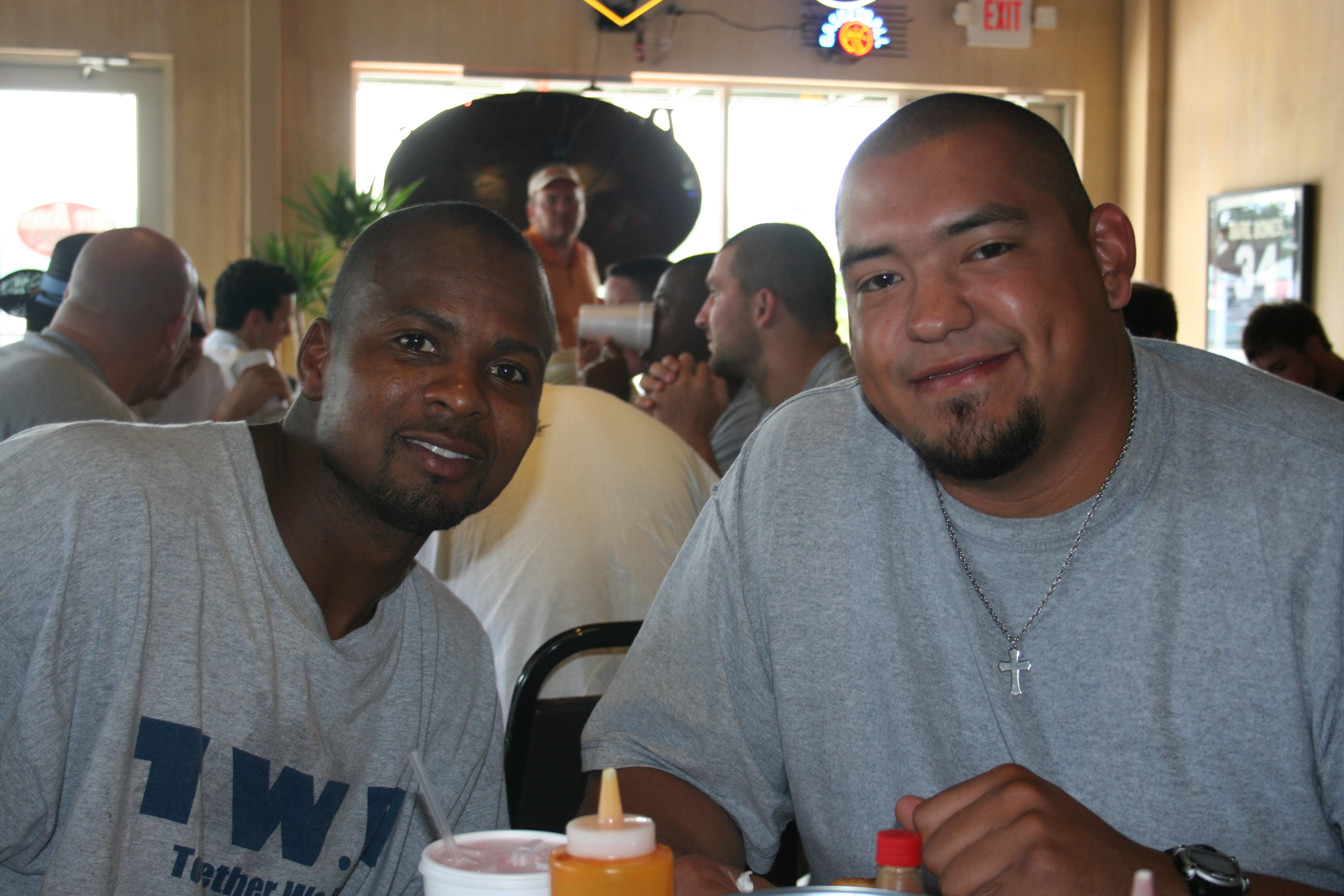 Robert Kilow, Receiver, and James Cardenas, Center smile for SYNC at Barebones BBQ.
