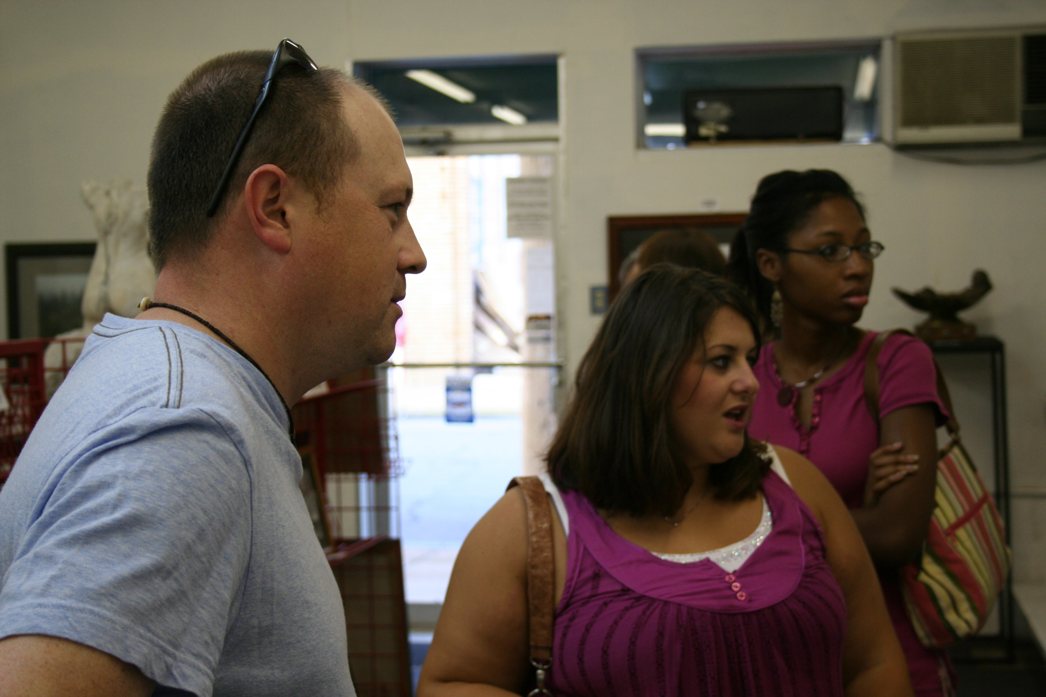 Thomas Pickle of North Little Rock, Meredith Floyd and Whitni White peruse the paintings and photos on display Saturday at Riciano Art Gallery in Conway.