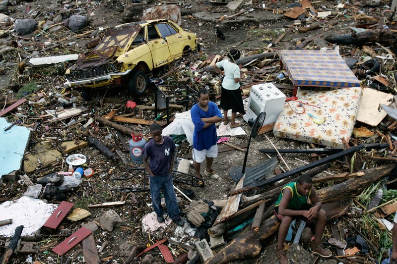 Residents of the coastal Bullbay neighborhood on Monday survey the damage to their property from a surge during the pass of Hurricane Dean near Jamaica. Jamaica avoided a direct hit when the storm passed to the south Sunday night.