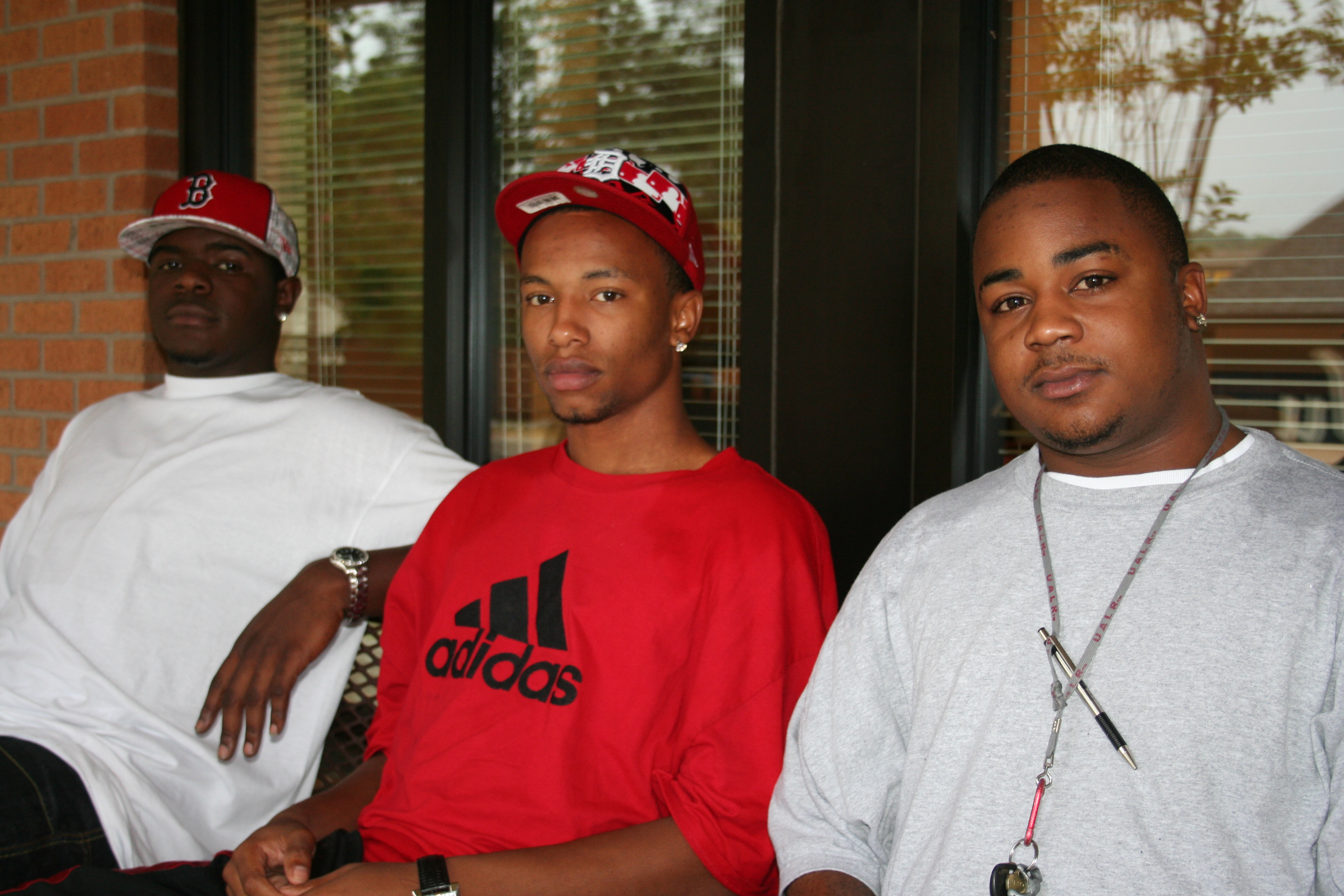 Trent Gibbs, Zacc McClure and Tristan Stuart hang out on a bench on a rainy afternoon.