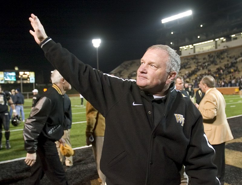 Wake Forest coach Jim Grobe waves to fans as he leaves the field after his team defeated North Carolina State in a football game in Winston-Salem, N.C., in November 2007.