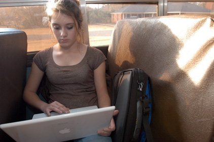 Shayna Tanner, an eighth-grader at Sheridan Middle School, does homework with her laptop while riding the bus to her home in Grapevine. 