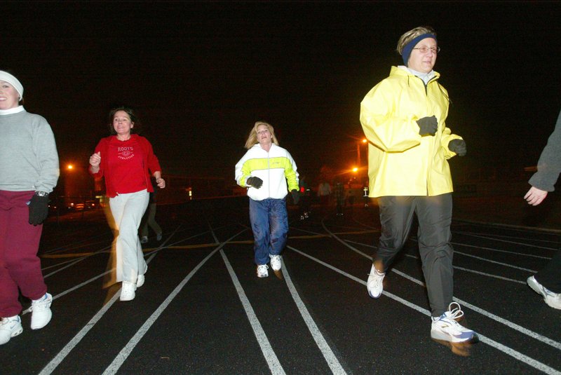 Women jog during the Women Run Arkansas club's Women Can Run/Walk group-training clinic Monday night at Sylvan Hills High School track.